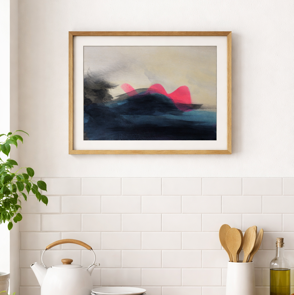 Abstract painting in a wooden frame on a kitchen wall with a teapot and utensils below.