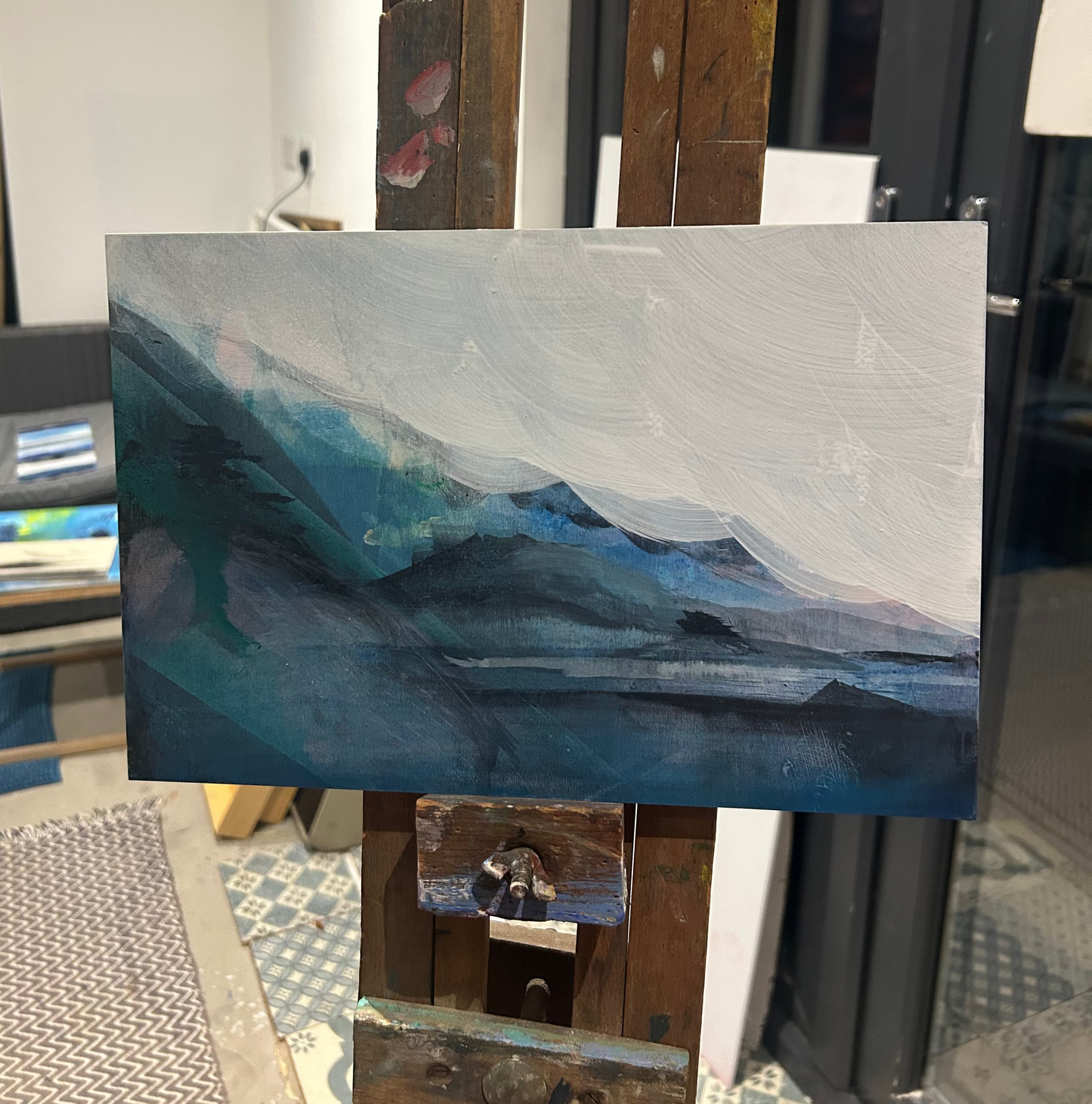 Abstract painting on an easel with a blurred indoor background